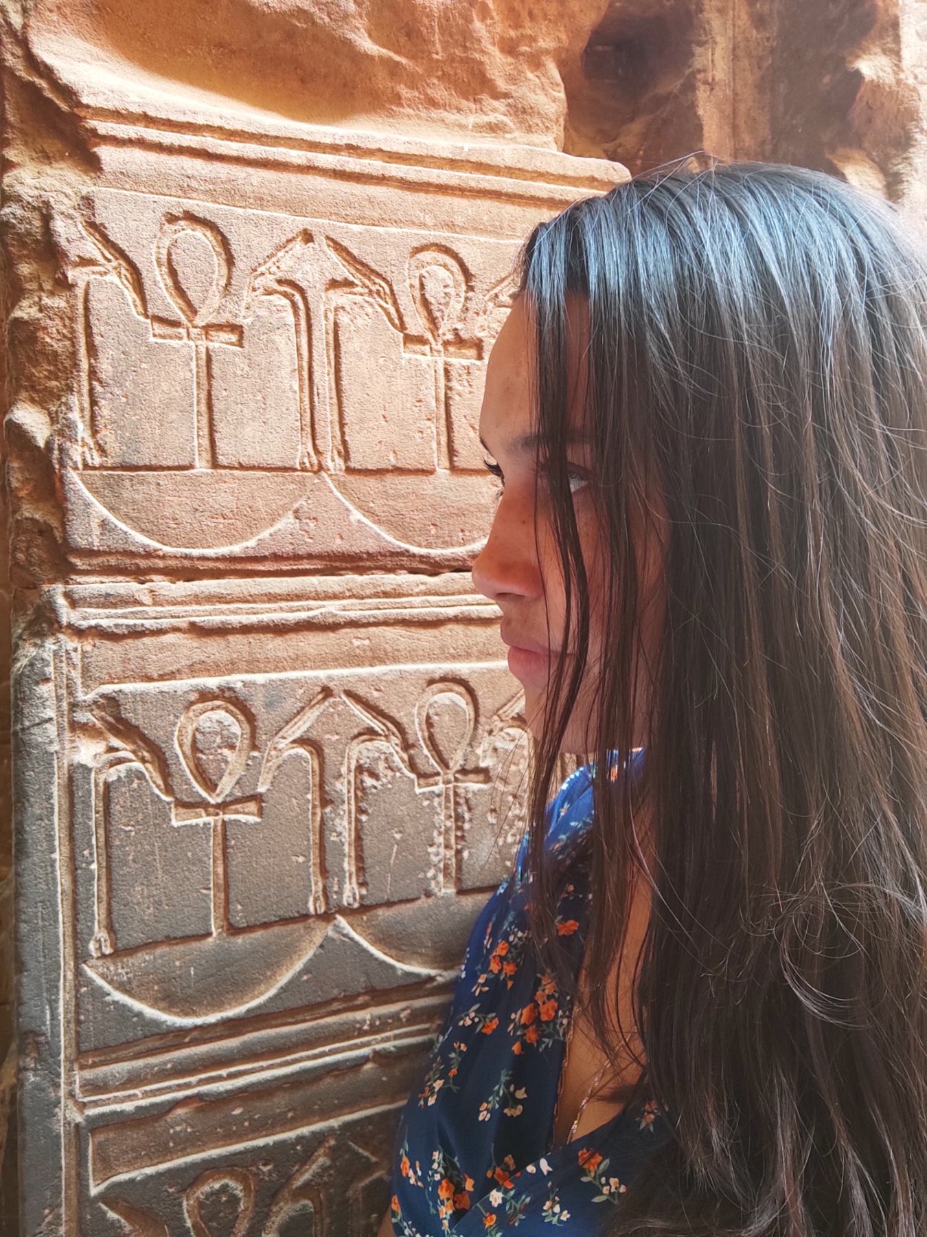 Letícia Bhakti diante de inscrições com Ankh
